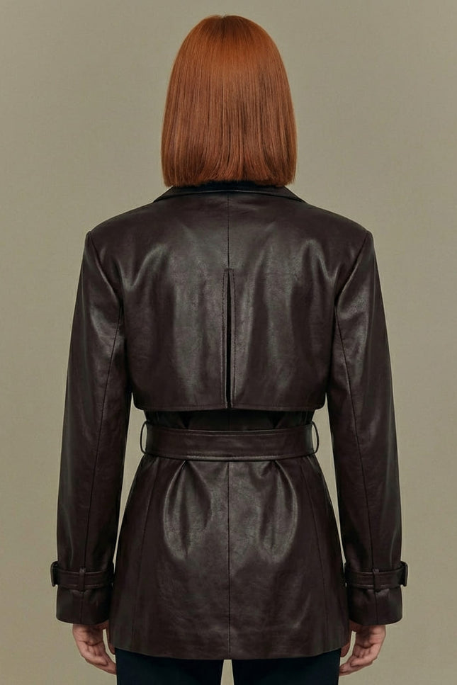 Person wearing a brown leather jacket against a beige background