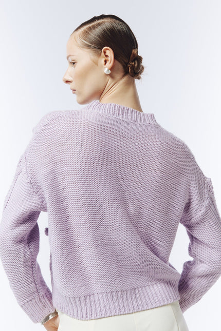 Soft lilac cable and bobble-knit jumper, back view on model showing plain knit back and ribbed hem.