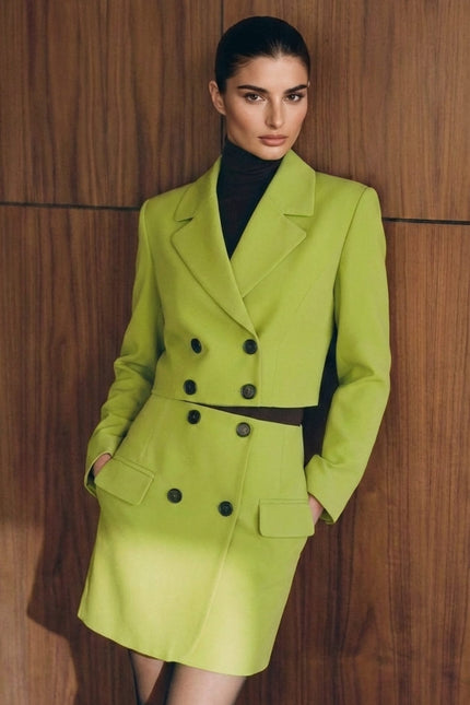 Woman wearing a bright green suit against a wooden paneled wall