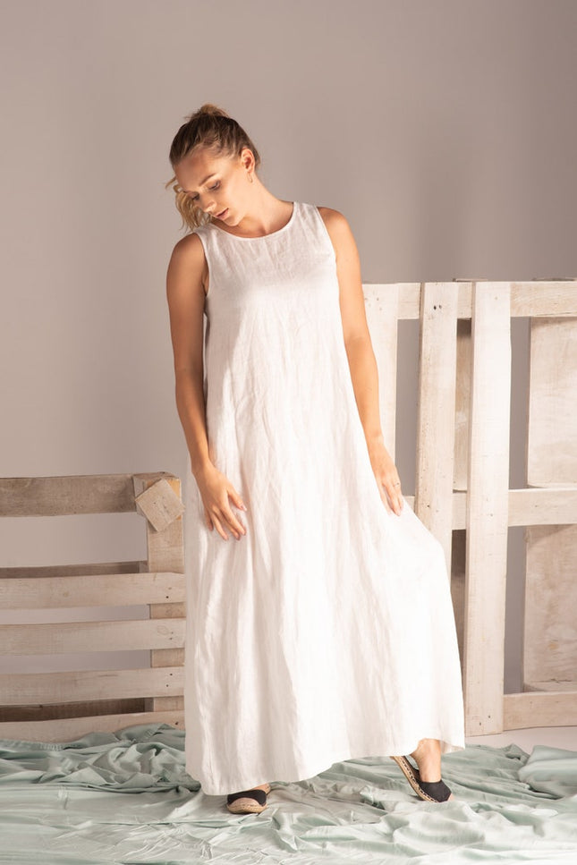 Model wearing Minimalist Linen Maxi Dress in front of a beach background - from NikkaPlace | Effortless fashion for easy living