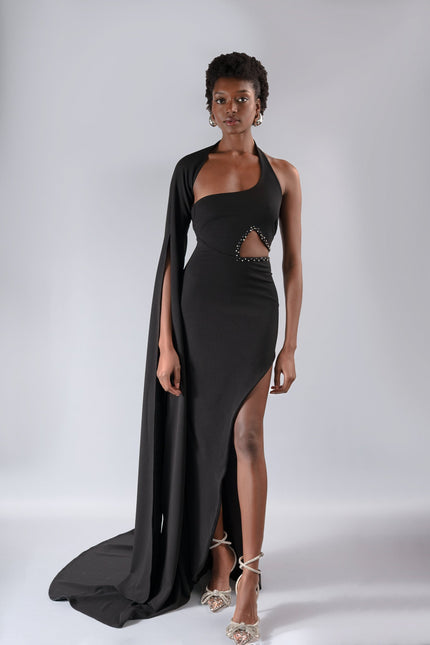 A woman wearing a long  black  dress by Anitabel, posed against a light grey background.