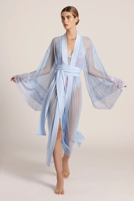Front view of a model wearing a long, blue mesh kimono, posing in a studio