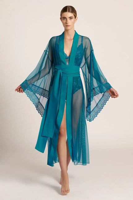 Front view of a model wearing a long, teal green mesh kimono, posing in a studio