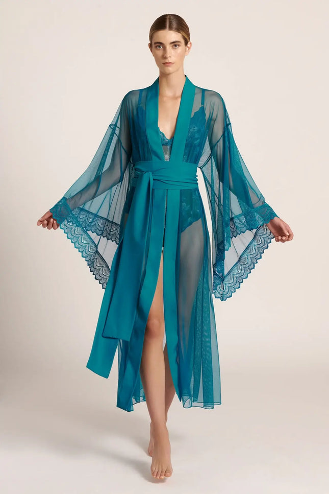 Front view of a model wearing a long, teal green mesh kimono, posing in a studio