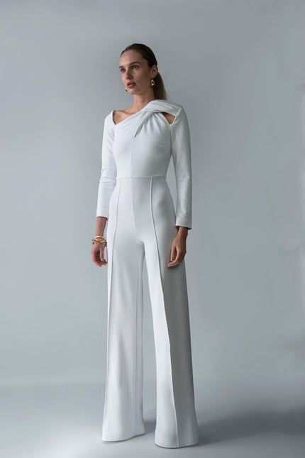 A woman wearing Meera white jumpsuit by  posed against a white background.