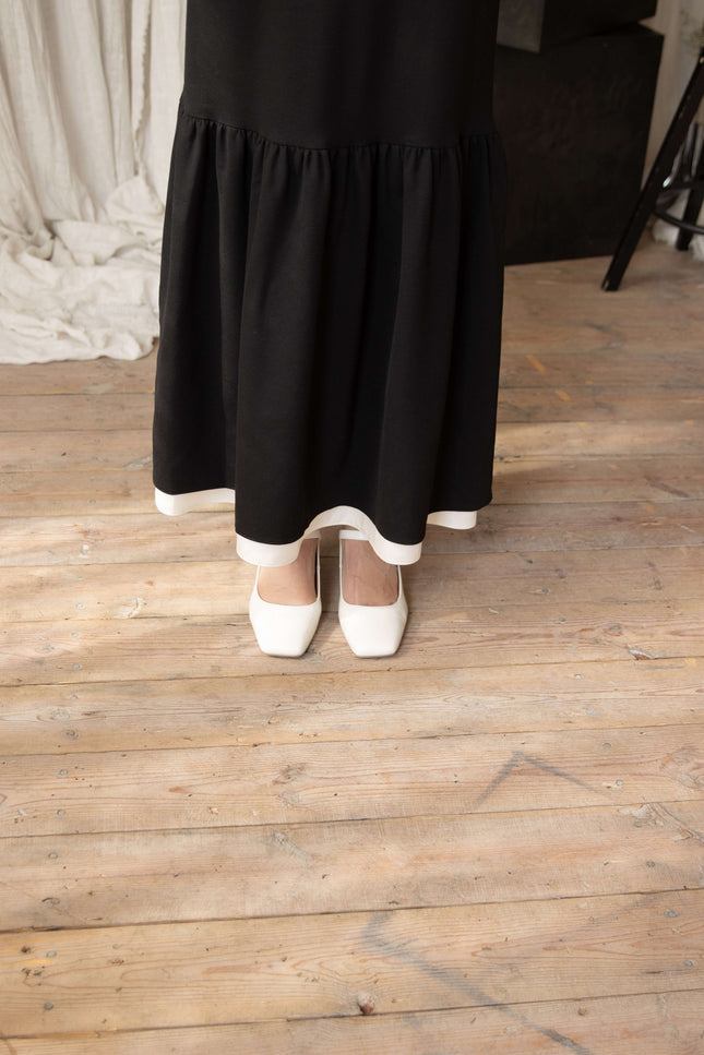 Black viscose formal dress with maxi length, slim fit bodice, flared hem, and graceful ruffle details.