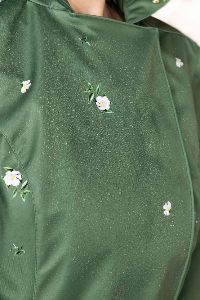 Delicate white floral pattern on fresh green waterproof women's trench coat by RainSisters