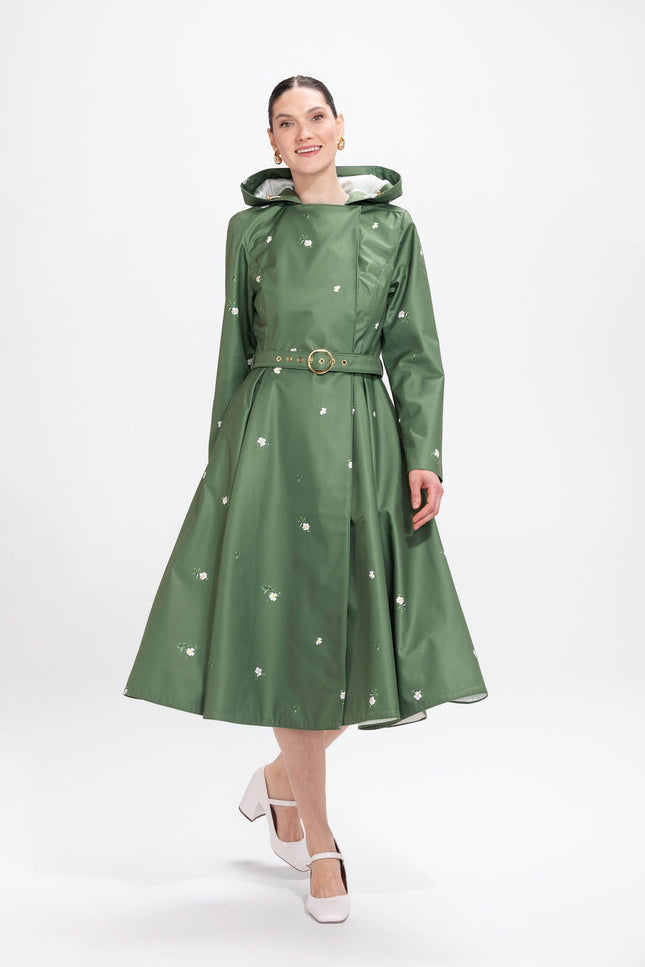 Model in motion wearing fresh green floral waterproof trench coat with tailored waist fit