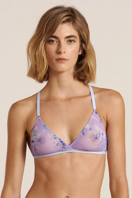 Front view of a model wearing a purple and blue mesh bralette, posing in a studio