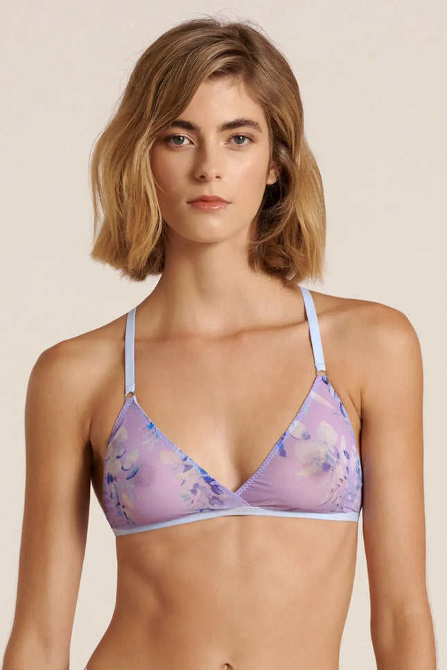 Front view of a model wearing a purple and blue mesh bralette, posing in a studio