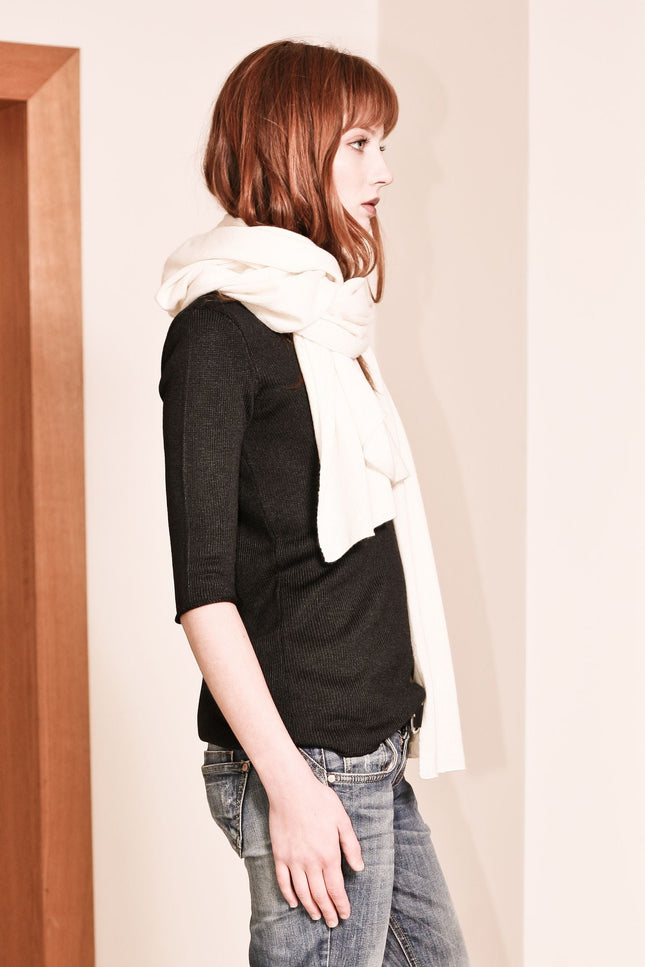 KIM, a travel wrap crafted from luxurious off-white cashmere, offers a cozy and stylish knitted scarf for your winter wardrobe.
