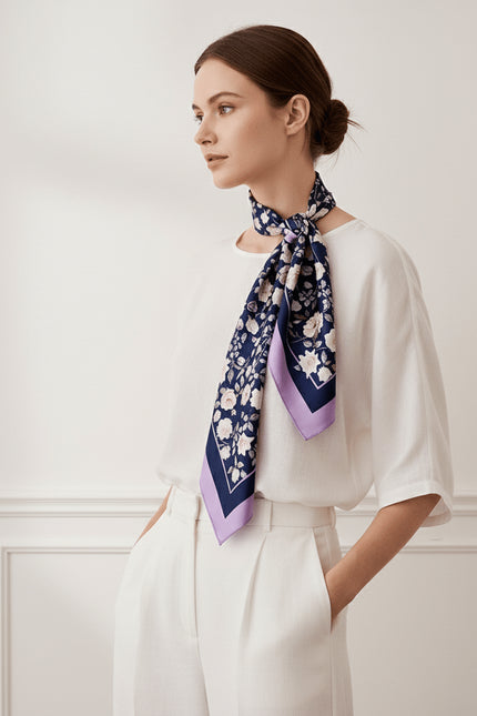 Side profile view of a model wearing a large silk scarf, showing the natural drape of the lavender border and detailed floral design.