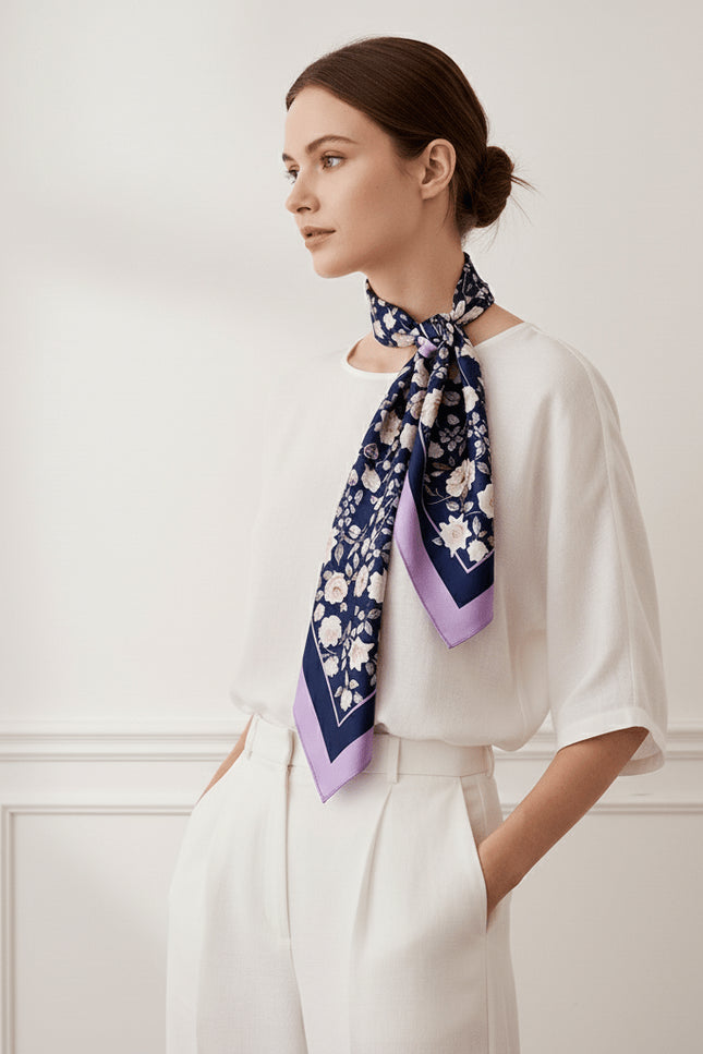 Side profile view of a model wearing a large silk scarf, showing the natural drape of the lavender border and detailed floral design.