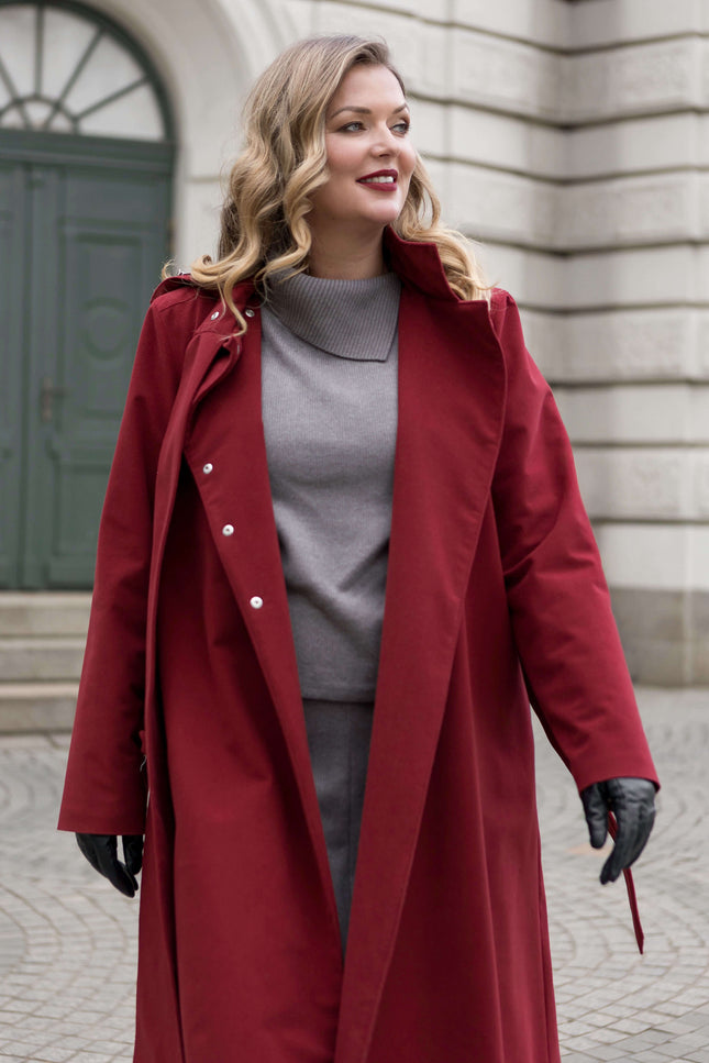 The double-breasted maroon coat by RainSisters flows gracefully, a luxury outerwear piece for the modern woman.